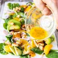 orange dressing is poured over the orange salad