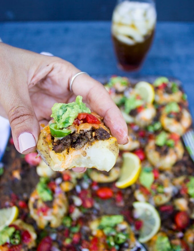 A hand holding a crispy smashed potato bitten showing how finger food can be