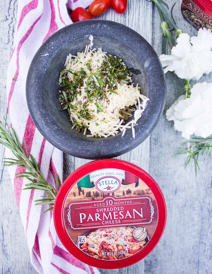 A mortar and pestle showing soft butter, herbs and Parmesan cheese 