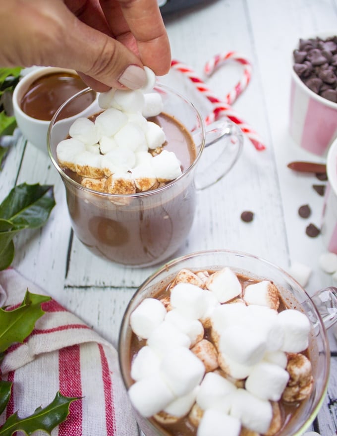 Adding marshmallows to the hot chocolate cups