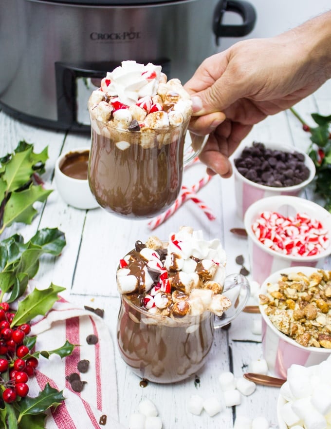 A hand picking up one of the hot chocolate cups