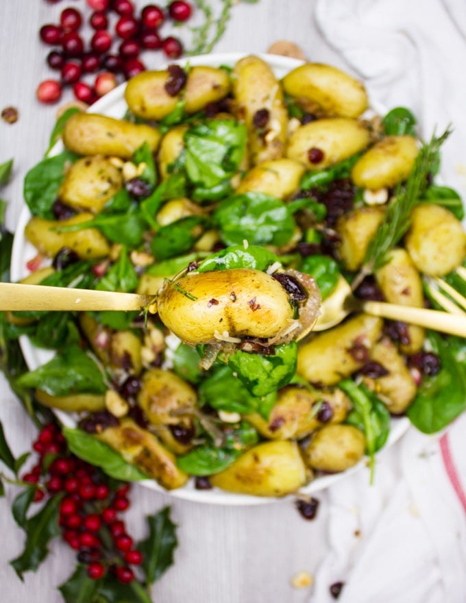 A spoon holding a potato close up from the potato salad recipe showing the crispy crust 