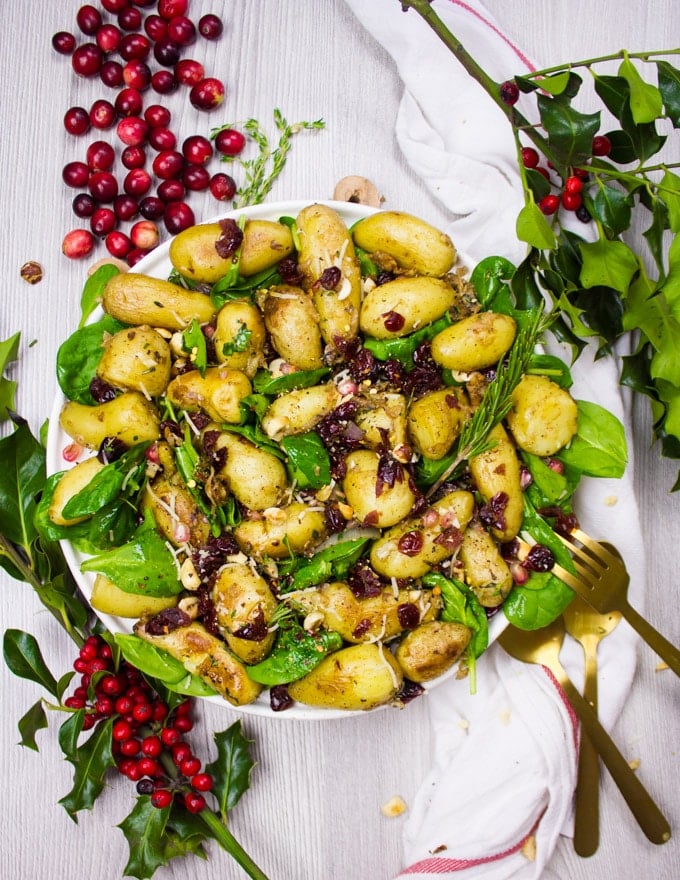 Plate of Potato Salad with spinach, cranberries and hazelnuts and two spoons