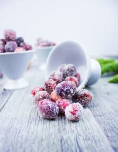 A bowl pouring sugared cranberries showing