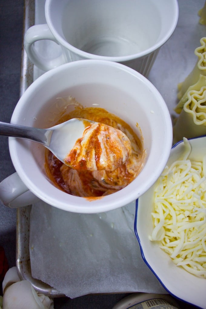 A spoon swirling the sauces to make a rosa sauce