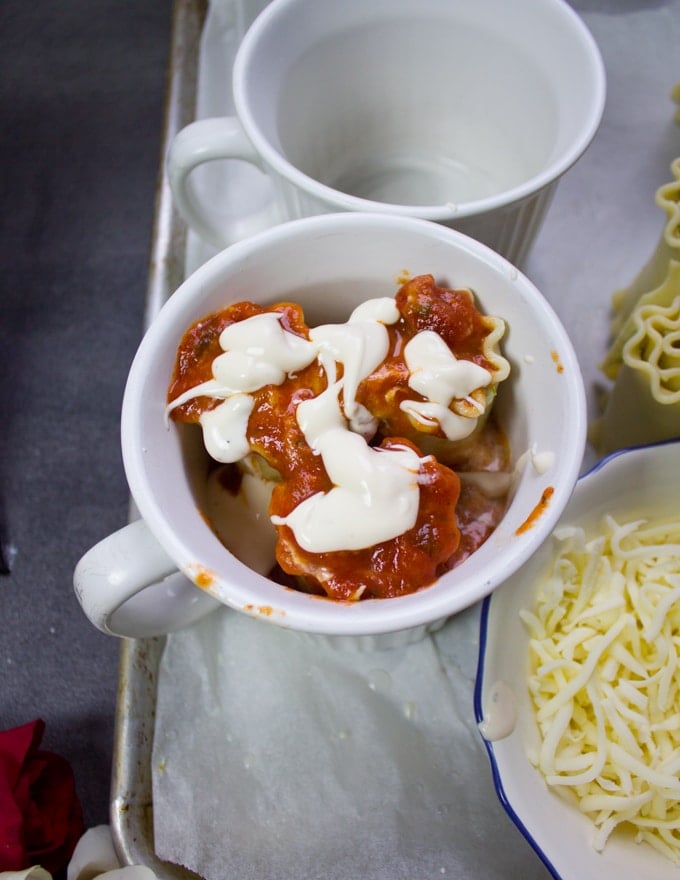 More marinara sauce and alfredo are put over the lasagna