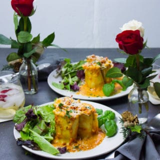 two plates ready to eat, two vases with roses, drinks and the perfect set up dinner for valentine's day