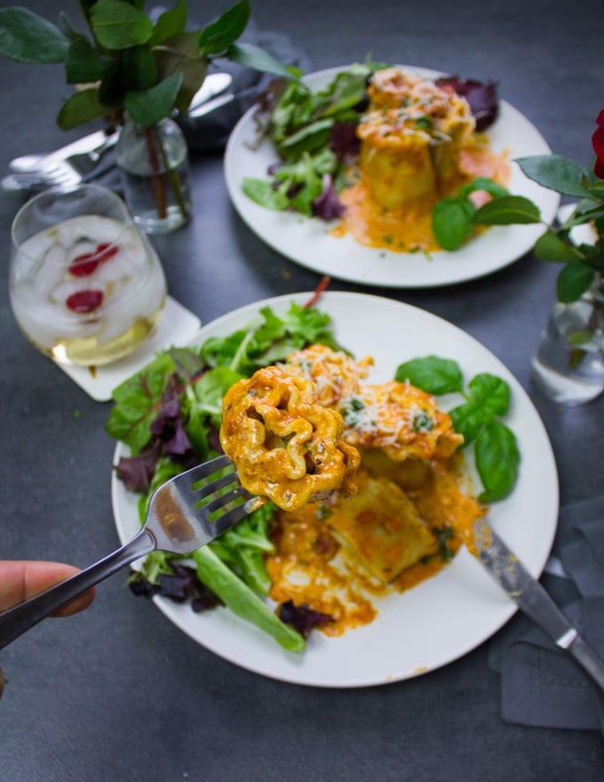 A hand holding a fork showing the cut off lasagna