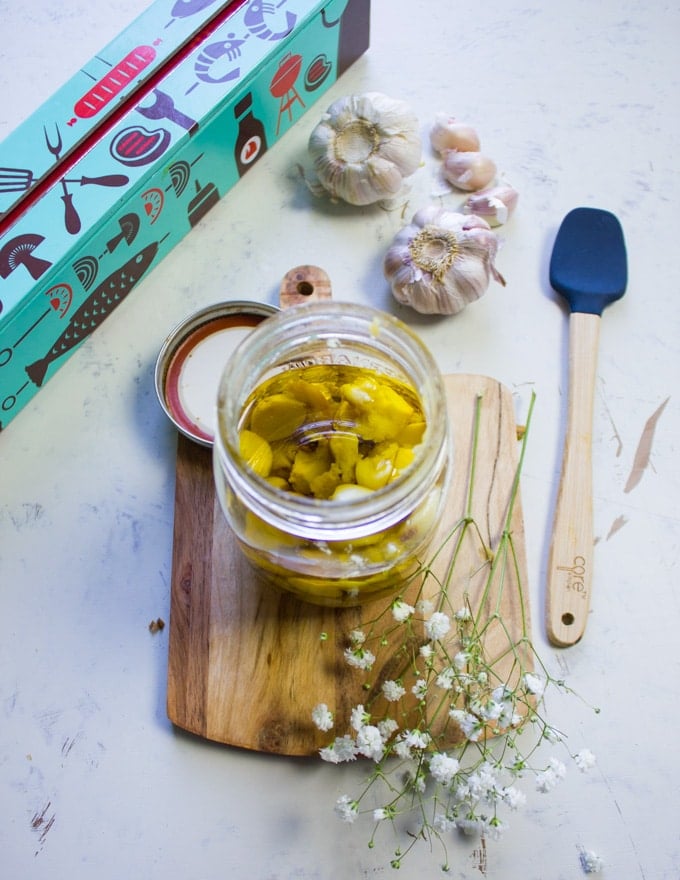 roasted garlic cloves in a mason jar with olive oil ready