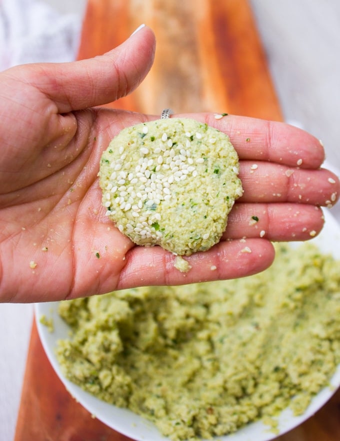 A hand holding a falafel mix and shaped ready to fry