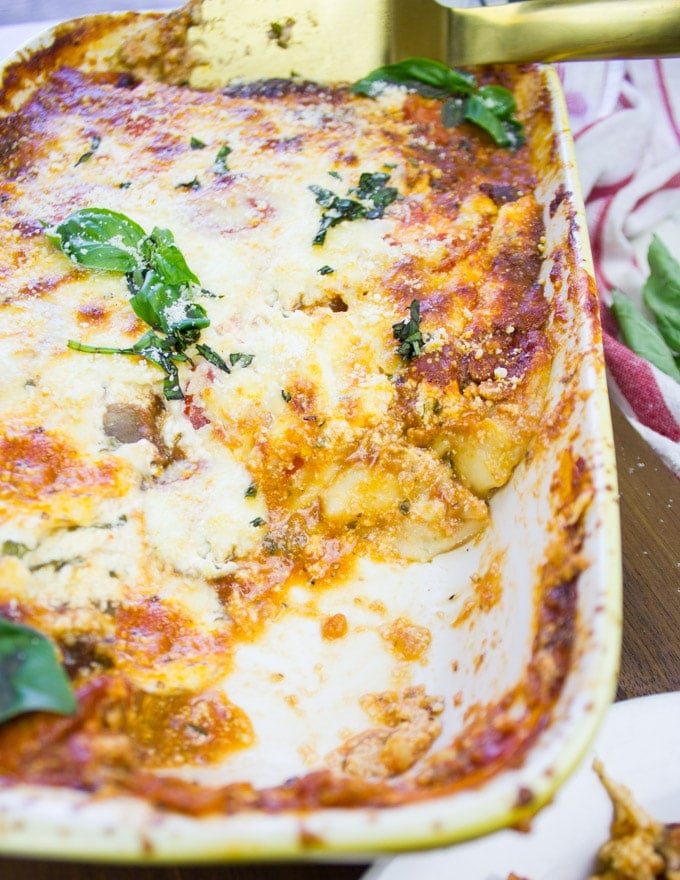 A plate of cooked lasagna half empty showing the inside of the lasagna cooked