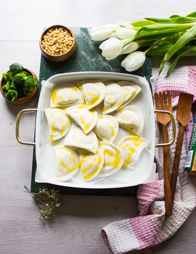 Frozen Pierogies on an oven safe baking dish drizzled with olive oil and ready for the oven