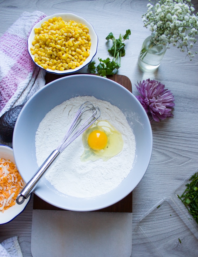 Egg added to the flour baking powder bowl to make corn fritters batter