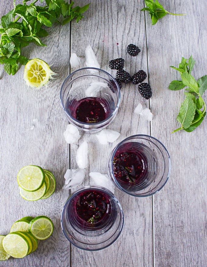 The blackberry, mint and lime mixture divided between three cups and ready for garnish and soda to be added 