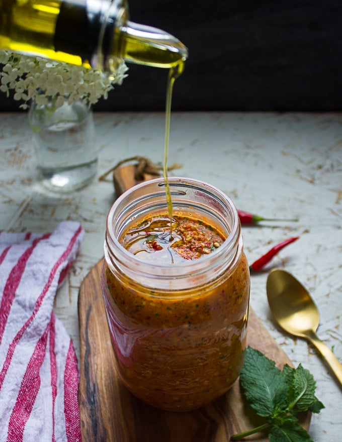 The sauce placed in a mason jar and then drizzled with olive oil 