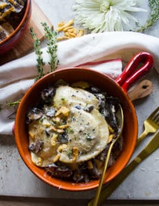 One bowl of Alfredo Recipe with pierogies, mushrooms, crispy onions and a fork