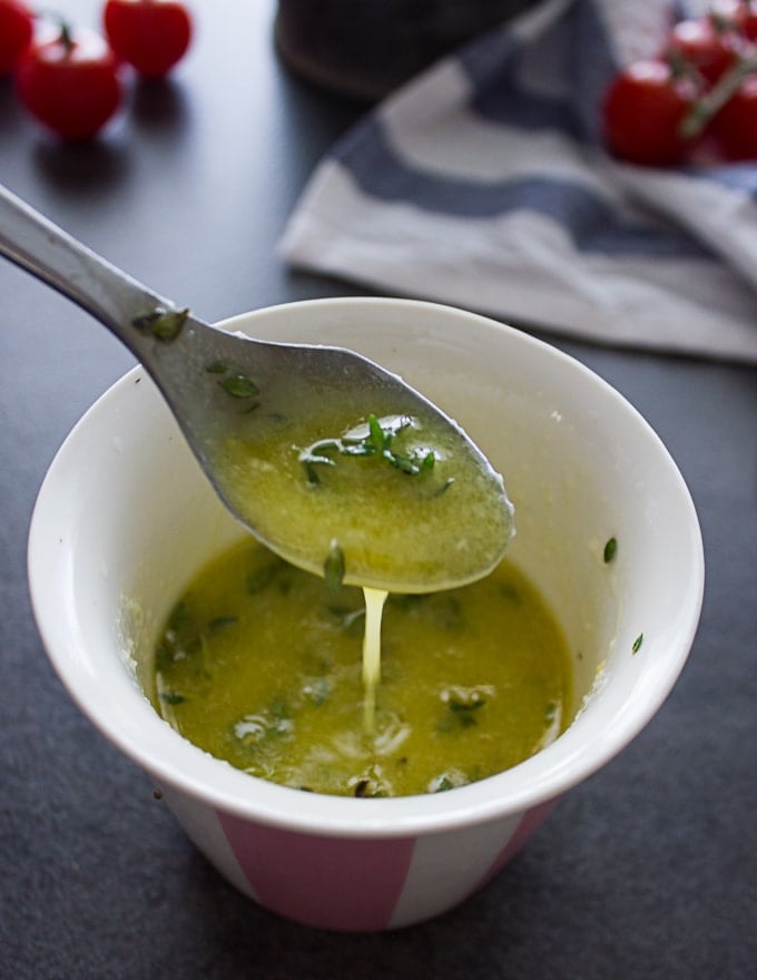 A spoon showing the final salad dressing mixed and showing the consistency of the dressing