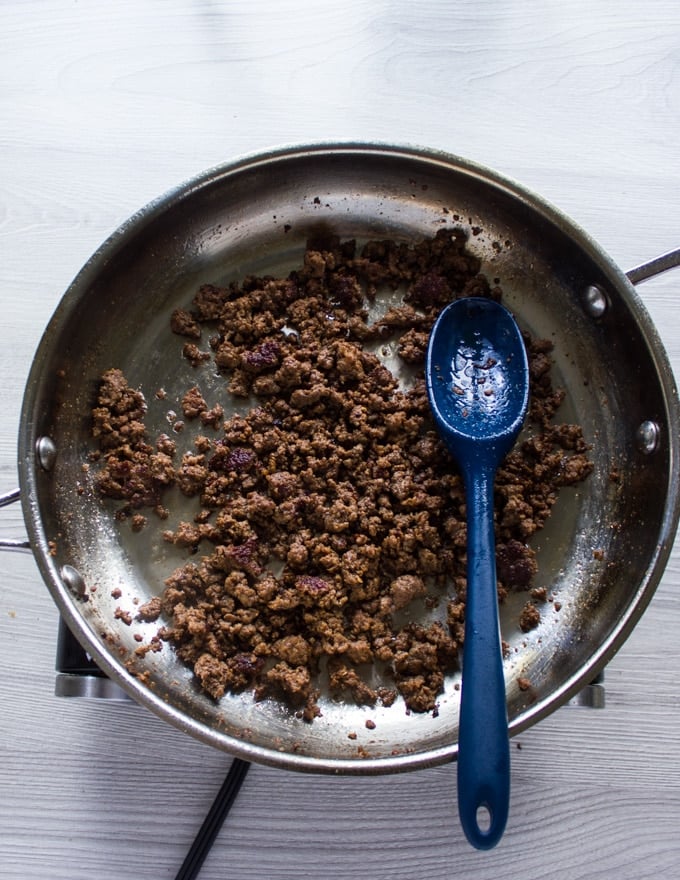 Cooked lamb crumbles in a skillet