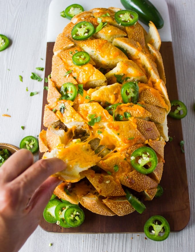 A whole load of cheesy pull apart bread close up and stretching out cheese