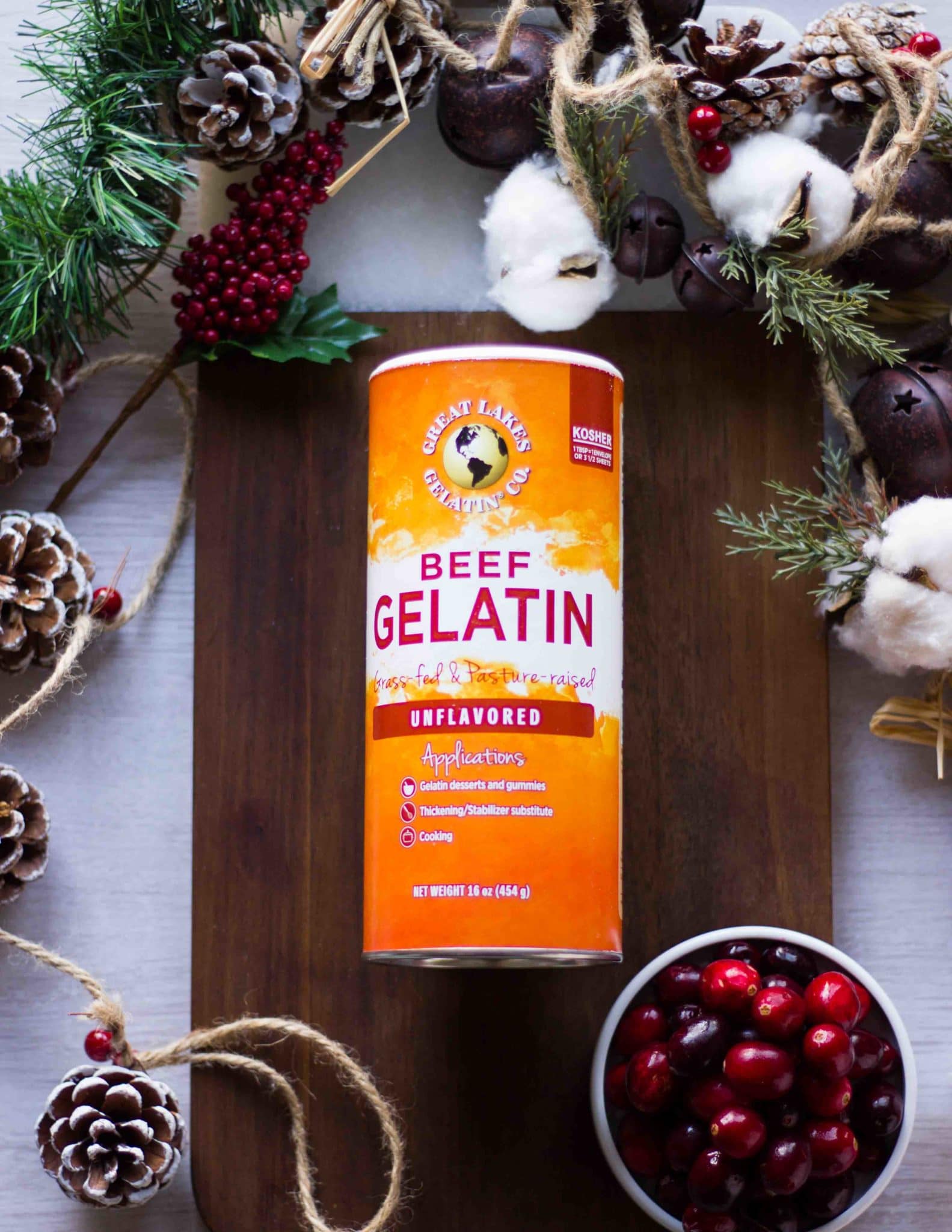 a box of great lakes beef gelatin on a wooden board surrounded by cranberries 