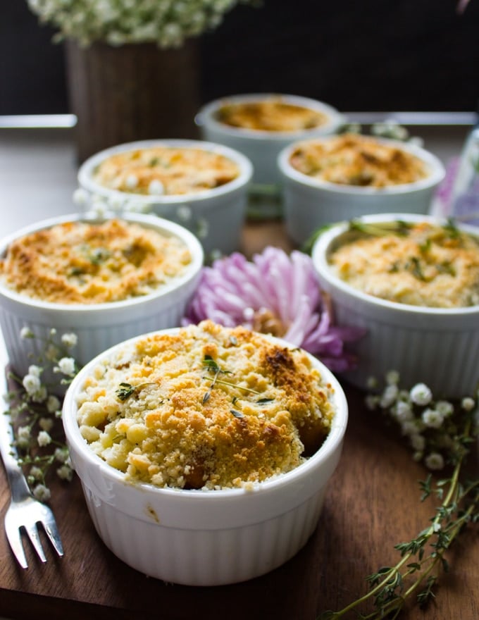 six sweet potato ramekins arrange on a wooden board with the gratin topping