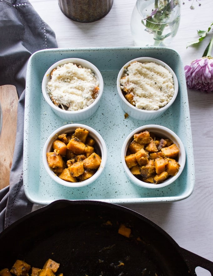 four ramekins in a baking tray and the sweet potatoes distributed among them