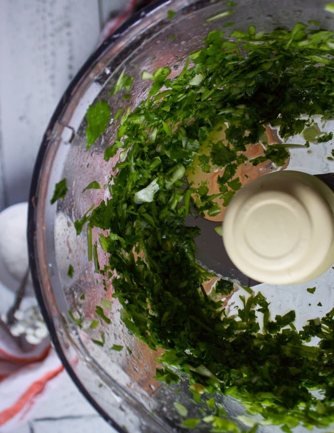 a bowl of food processor showing the ingredients processed and chopped finely.