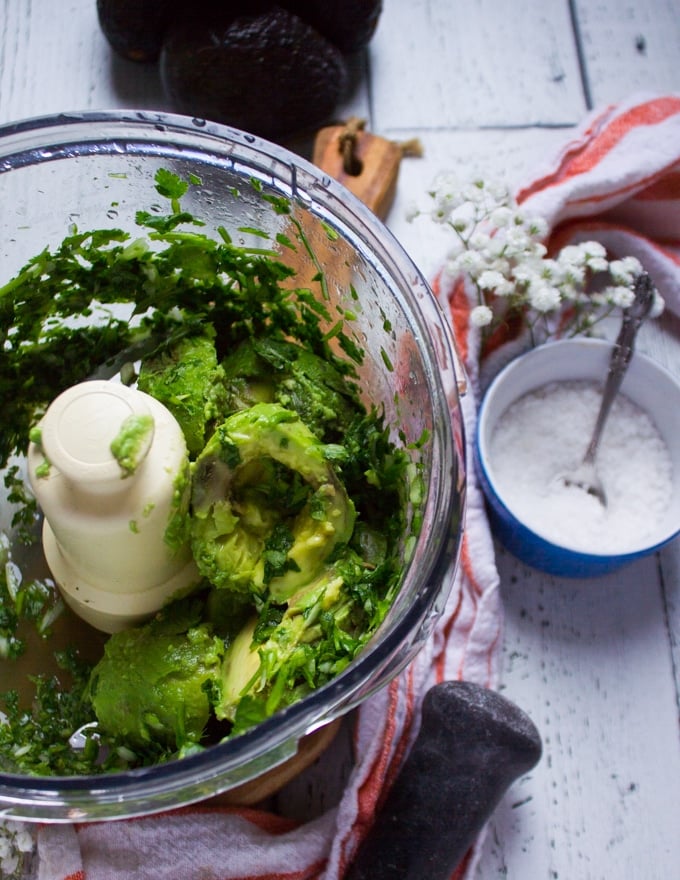 The avocados added to the food processor and ready to turn into guacamole