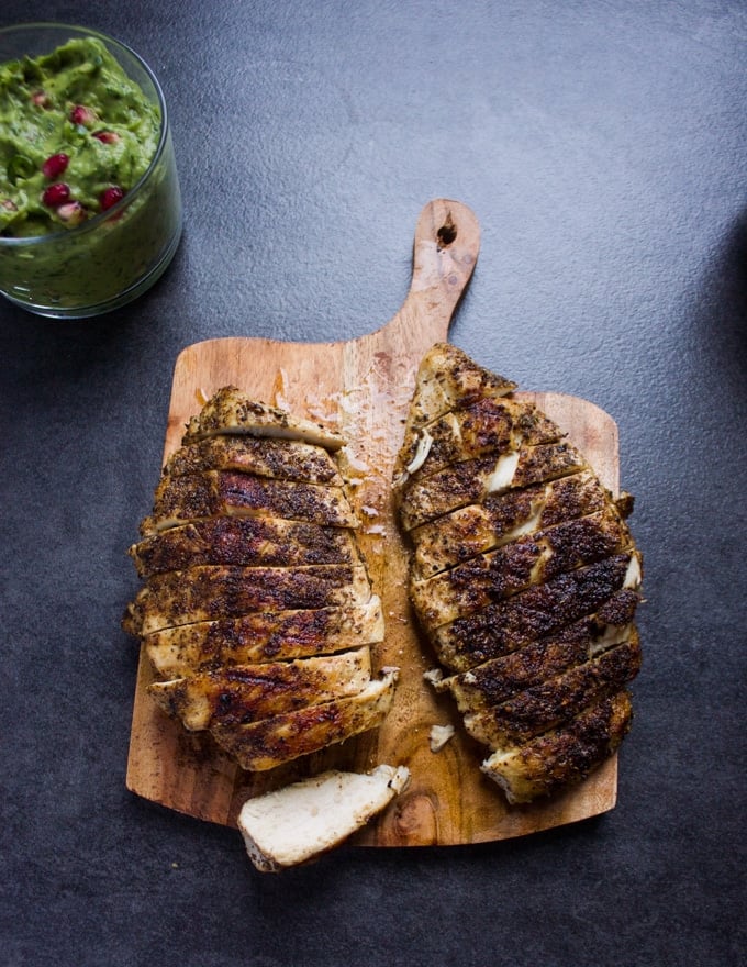 Fully cooked chicken breasts on a wooden board sliced into half an inch slices