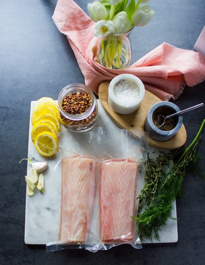 Ingredients for baked mahi mahi recipe including: 2 mahi mahi fish fillet defrosted, salt and pepper, chilli flakes, fresh herbs, garlic and lemon slices, and butter