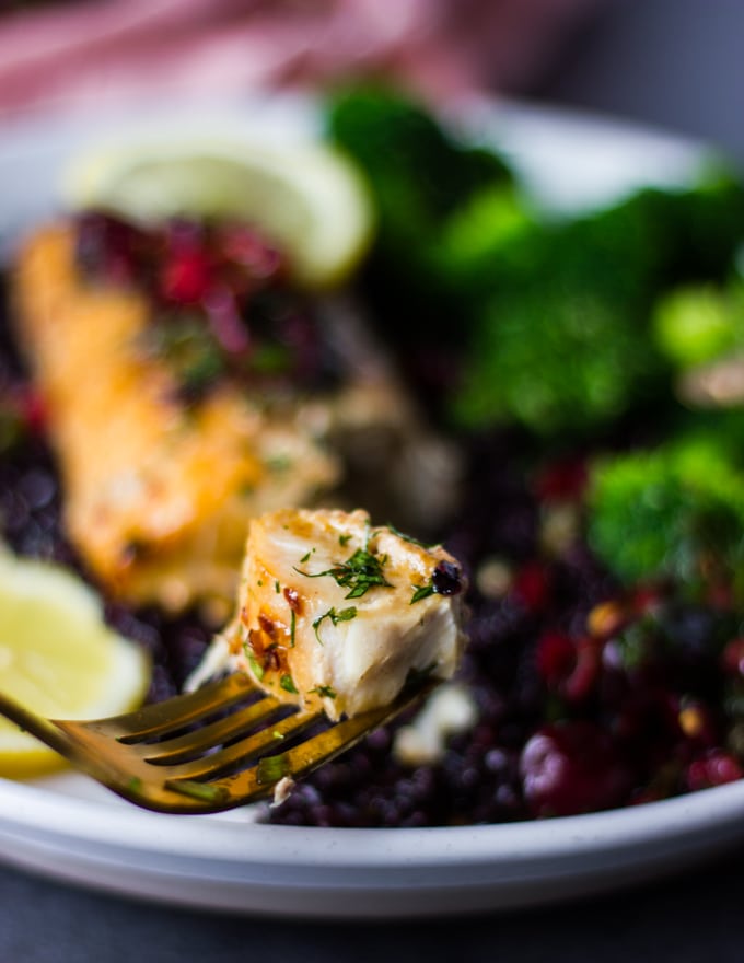 A fork showing a bite of baked mahi mahi fish texture and juicy baked fish