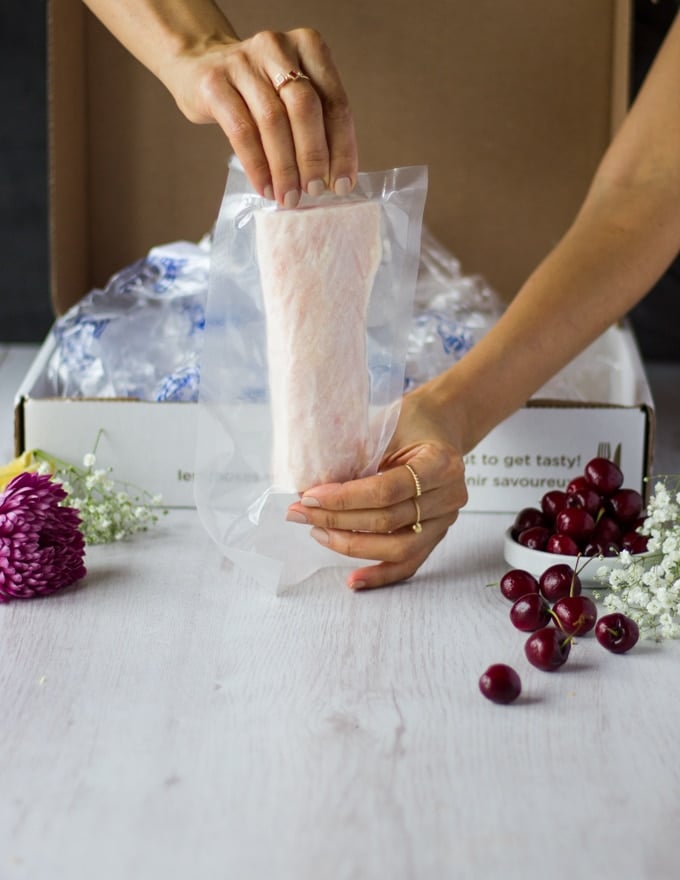 A hand holding an individually wrapped Mahi Mahi Fillet ready to defrost and bake 