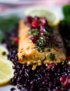 A fillet of baked mahi mahi over black rice and some cherry salsa over the top