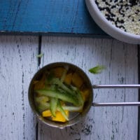 shredded cucumbers added over the mango chunks in the same measuring cups