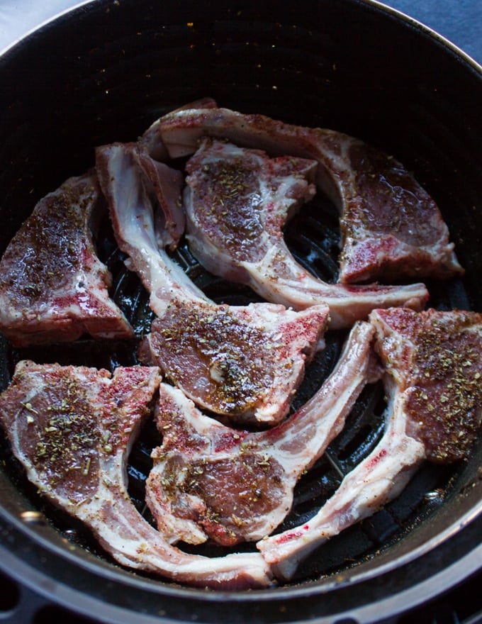 Lamb Chops seasoned and arranged in the air fryer basket in a single layer ready to air fry