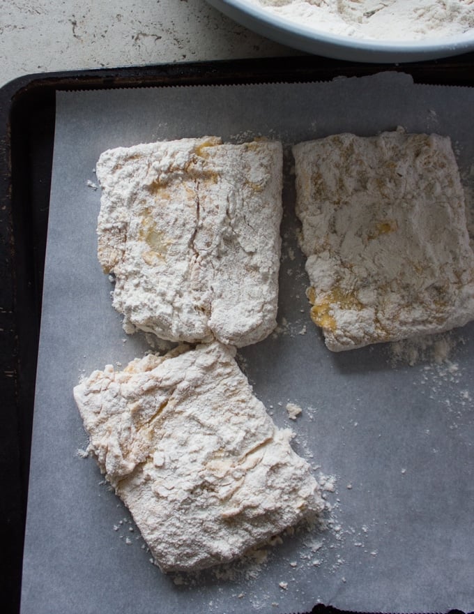 finished coated fish on a parchment paper ready for frying