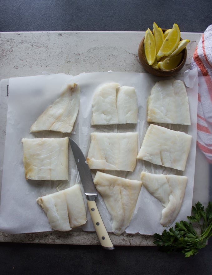 Fish fillets on a white paper and cut up into thirds 