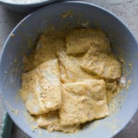 The fish fillets dredged in the egg sticky mixture next for the breading porcess