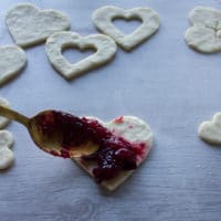 A spoonful of cherry pie filling placed at the bottom of the cherry pie crust