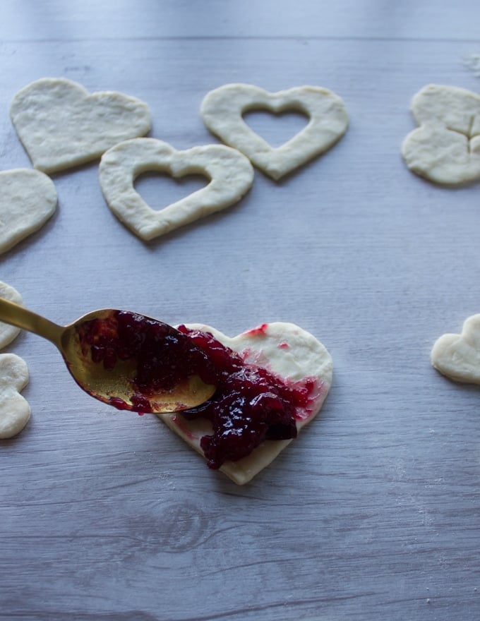 A spoonful of cherry pie filling placed at the bottom of the cherry pie crust