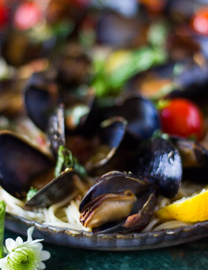 The cooked mussels marinara added over the pasta 