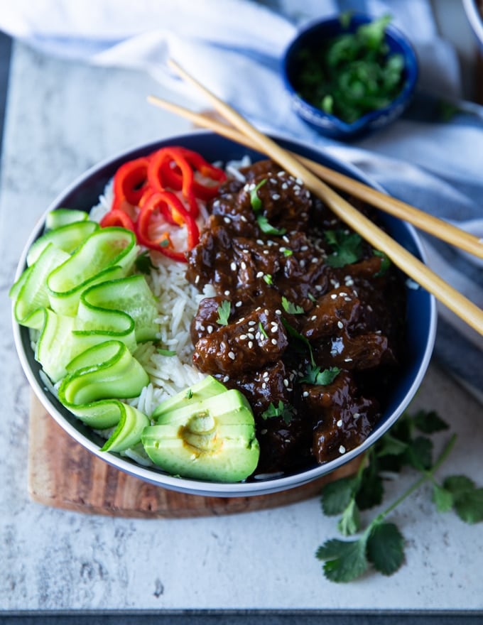 Close up of a single bowl of beef tips recipe and rice showing the texture of the cooked beef tips and the rice