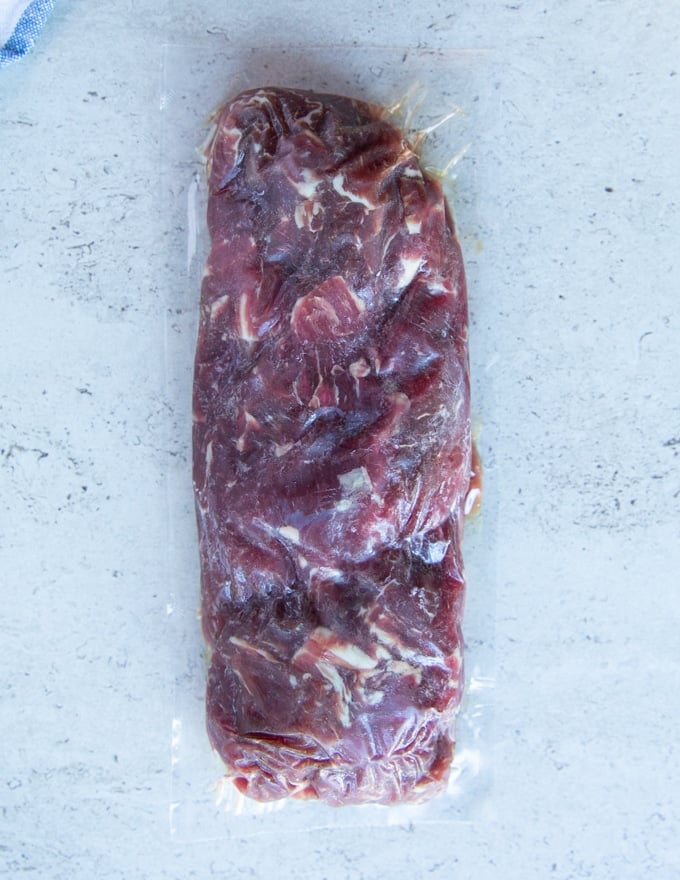 A block of frozen beef tips ready to defrost