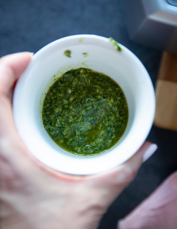 A hand holding a bowl of the marinade for the boneless leg of lamb