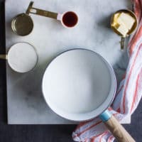 Ingredients for homemade caramel sauce including sugar, butter, vanilla, water and some cream