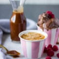 Homemade caramel sauce in a jar and a cup of coffee to drizzle the sauce on