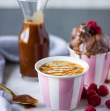 Homemade caramel sauce in a jar and a cup of coffee to drizzle the sauce on