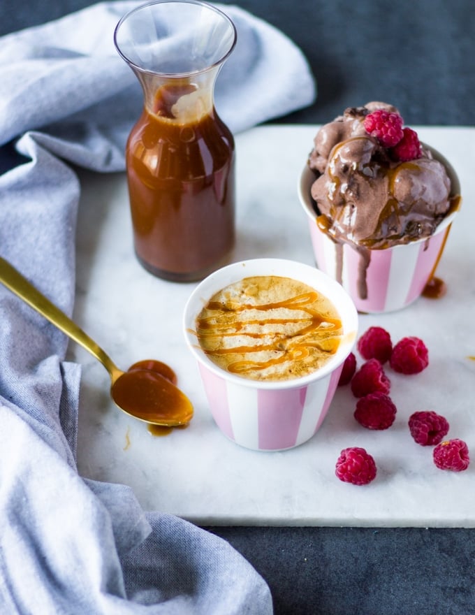 Jar of caramel sauce, caramel sauce on ice cream, and coffee drizzled with caramel on a tray with raspberries.
