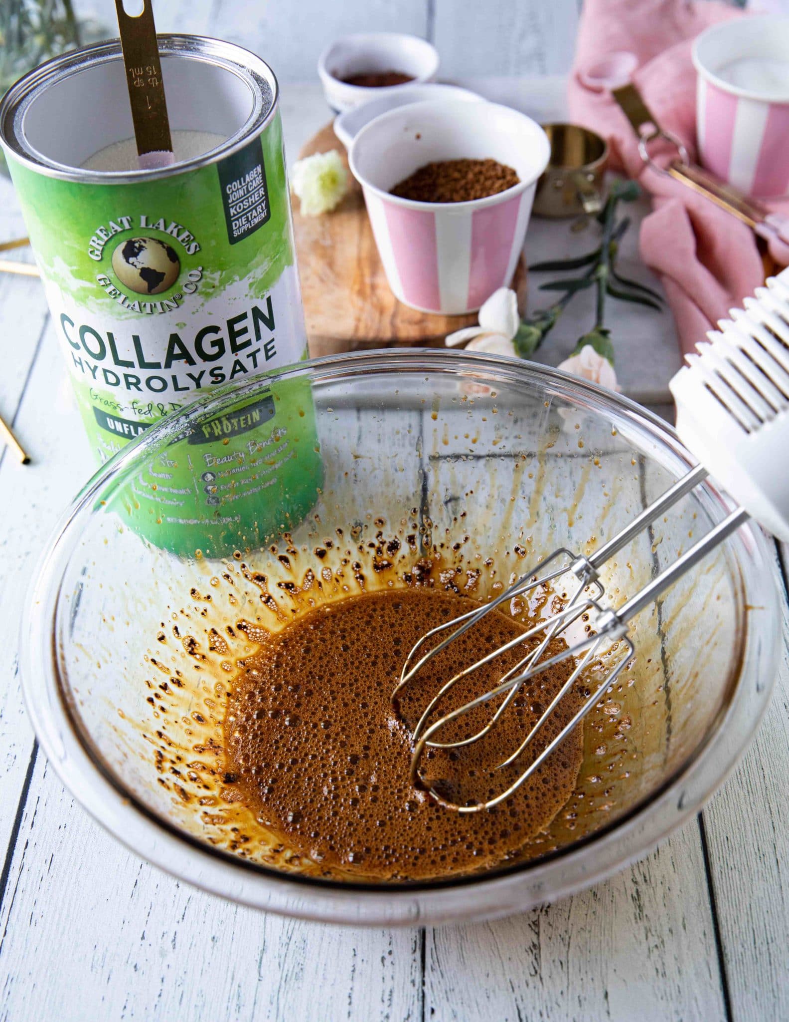 All ingredients to make whipped coffee in a bowl and an electric mixer next to it