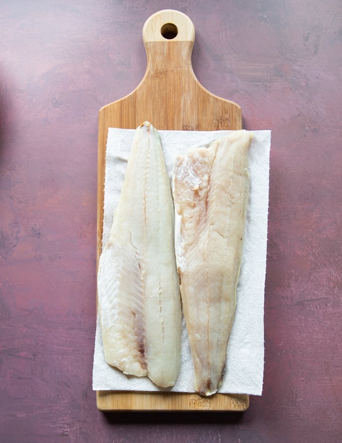 pickerel fillets on a cutting board thawing.